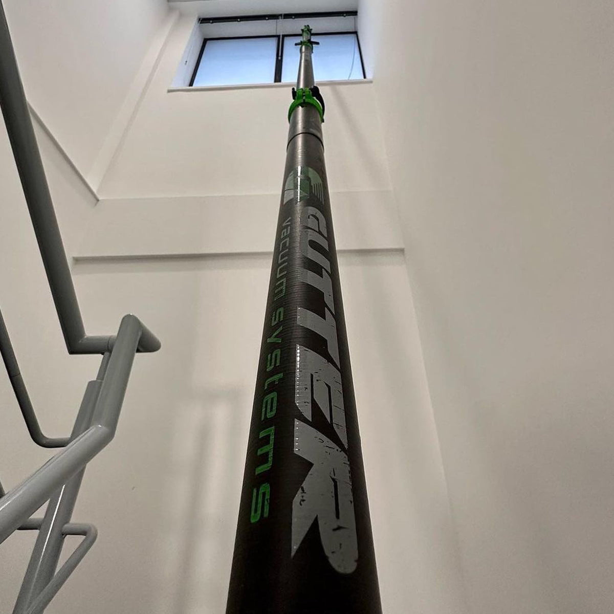 Gutter vacuum poles clear water from high level internal glass windows